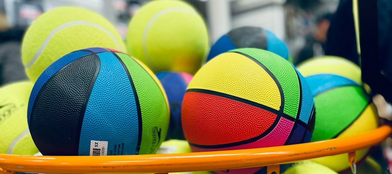 a pile of tennis balls sitting on top of a rack